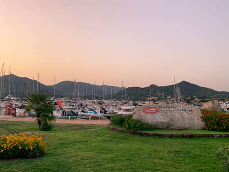 Villasimius, Italy - August 12, 2019: Sunset on the marina of Villasimius. Recreational boats are still in calm water.のeditorial素材
