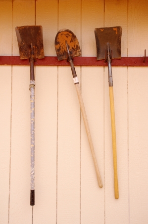 Three old hanging shovels for shoveling sandの写真素材