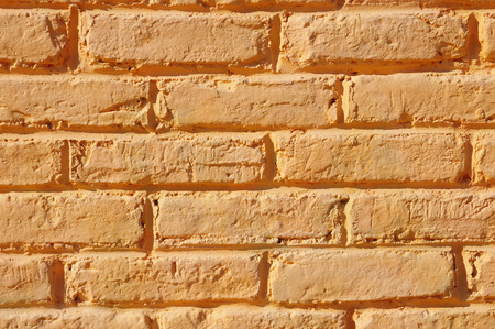 Orange painted brick wall closeup in sunny day