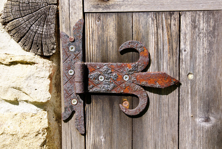 Old rusty door hinge on wooden doorの写真素材