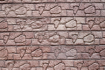 Red decorative relief plaster imitating stones on wall closeupの写真素材