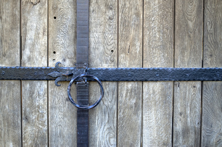 Metal black round handle on wooden door  in sunny dayの写真素材