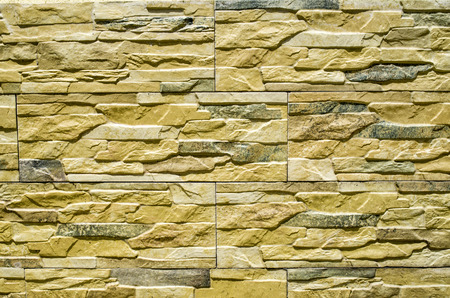 Decorative relief cladding slabs imitating stones on wall closeup