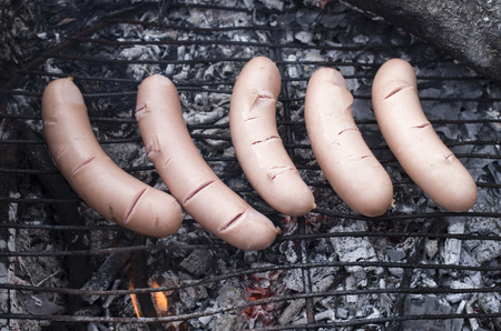 Grilled sausages on campfire closeup in summer dayの写真素材
