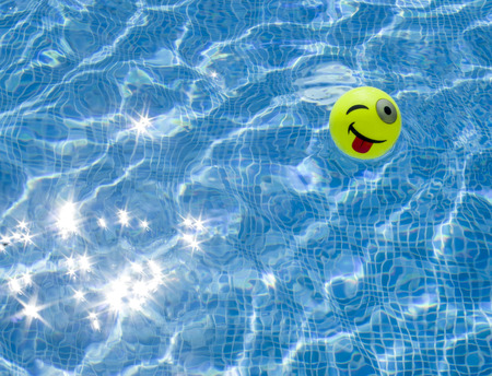 Swimming pool and small ball with protruding and winking faceの写真素材