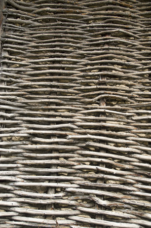 Old wicker wooden wall plastered with mud closeup
の写真素材