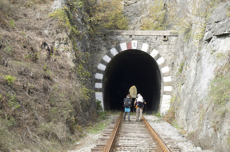 Old railway stone tunnel and people in autumn dayの写真素材
