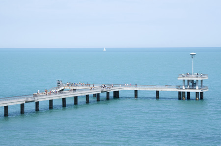 A bridge with a pier and jumping and walking people in the summer Burgas, Bulgaria