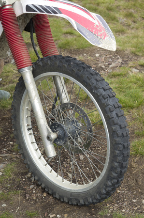Front tire and fender on a motorcycle with a red damper