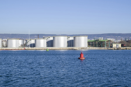 Big metal industrial oil tanks on port in petroleum base の写真素材