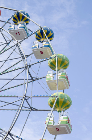Colorful Ferris Wheel with cab with shape of air baloon in blue skyの写真素材
