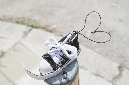 Small clean torn sneaker toy with heart-shaped ropeの写真素材