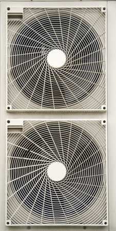 Two air conditioning fans closeup on outside wall part of ventilation systems