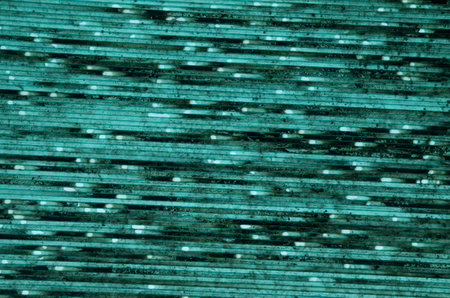 Old green plastic surface with lines and spots closeup