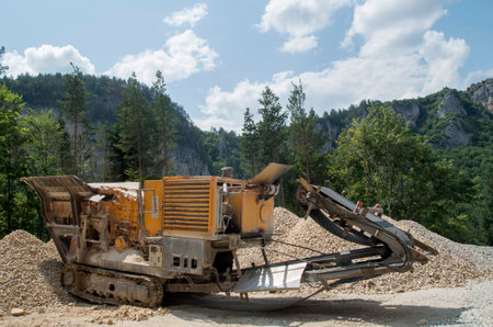 Old small mobile stone crusher crawler machine  in sunny day