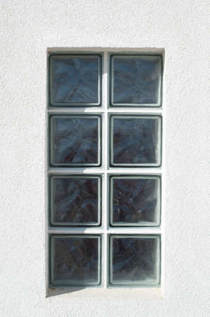 One glass block window looking outside on white wall