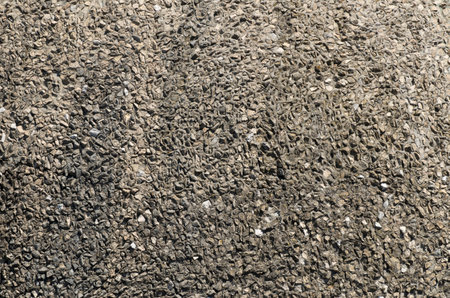Old gray stone wall with concrete and gravel close upの写真素材