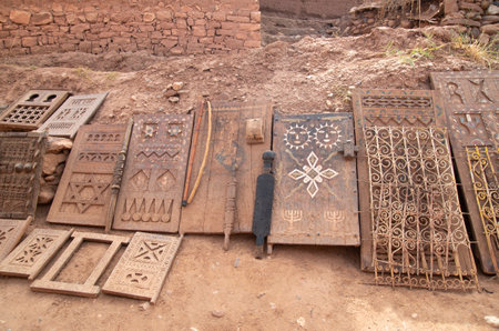 Old Moroccan carved interior wooden doors and wrought iron filigree for window in street trade in Ait Ben Haddou, Moroccoの写真素材