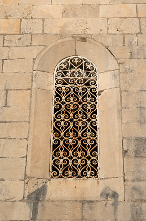 Old arched window  with white wrought iron on stone facade in Montenegro, Europeの写真素材