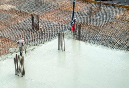 Concrete casting on reinforcing metal bars of a slab in new buildingの写真素材