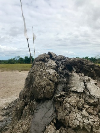 Crater of the recently erupted mud volcano displaying gray mud lava