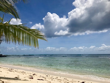Idyllic and beautiful beach in Barbados: Nobody, white sand, turquoise water, waves and white cloudsの写真素材