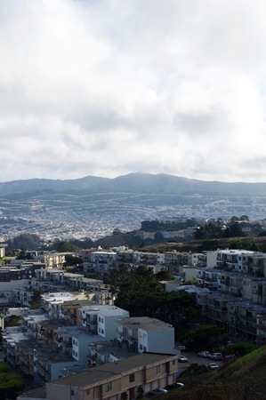 Beautiful aerial view of the San Francisco Twin Peaks overlooking the city's scenic skyline with numerous buildings and landmarks in the background - California, USAの写真素材