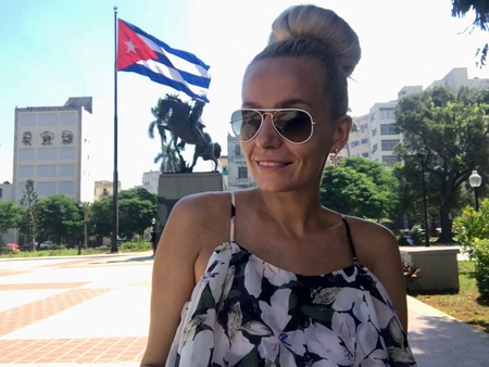 Beautiful young blonde female in Havana, Cuba with a Cuban flag in the backgroundのeditorial素材