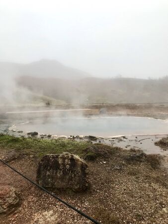 The Konungshver geyser, part of Haukadalur, the geothermal and geothermal features along the Golden Circle tourist route in Southern Iceland on a foggy autumn afternoonの写真素材