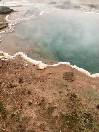 The Konungshver geyser, part of Haukadalur, the geothermal and geothermal features along the Golden Circle tourist route in Southern Iceland on a foggy autumn afternoonの写真素材