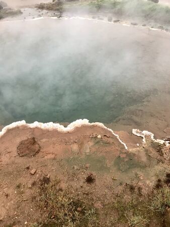 The Konungshver geyser, part of Haukadalur, the geothermal and geothermal features along the Golden Circle tourist route in Southern Iceland on a foggy autumn afternoonの写真素材