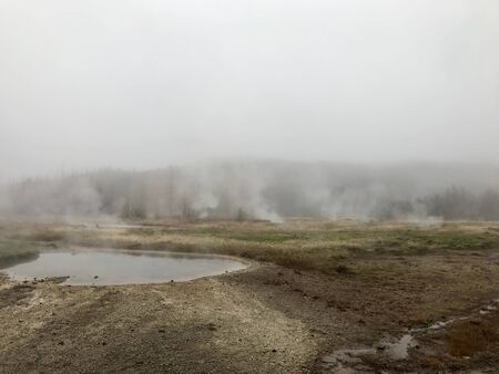 Nordic landscape in Haukadalur valley (Iceland) on a cold autumn / winter day in the geothermal area of The Great Geysir: mud roads, rocks & volcanic nature releasing hot water through geyser springsの写真素材