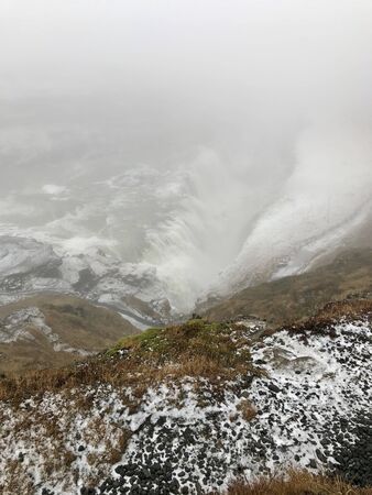 The majestic arctic Gullfoss waterfall landscape located in the canyon of the Hv?t? river on the Golden Circle Route in Iceland on a foggy autumn / winter day: Scenic cascades & cliffs with iceの写真素材