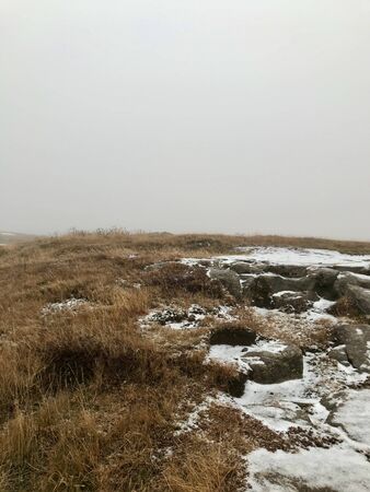 Scenic wilderness of the volcanic landscape along the Golden Circle Route in Iceland on a cold November day: First snow causes low visibility and a feeling of freedom hiking the lonely way to nowhereの写真素材
