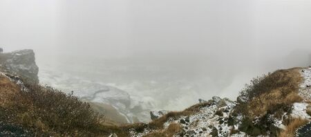 End of the world feeling at the cliffs of the Gullfoss Waterfall in Iceland: Frosted foggy winter...
