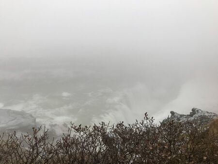 Majestic landscape of Gullfoss (golden waterfall) in Iceland on a cold November day: Outdoor scenery with water flowing down rocks and cliffs in a beautiful wild park in arctic North Europeの写真素材