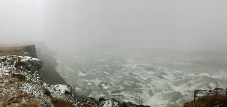 Majestic landscape of Gullfoss (golden waterfall) in Iceland on a cold November day: Outdoor scenery with water flowing down rocks and cliffs in a beautiful wild park in arctic North Europeの写真素材
