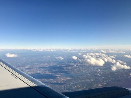 Beautiful birds eye view scene from air travel: Tranquil scenery of the airplane flying high above idyllic landscapes with its long wingの写真素材