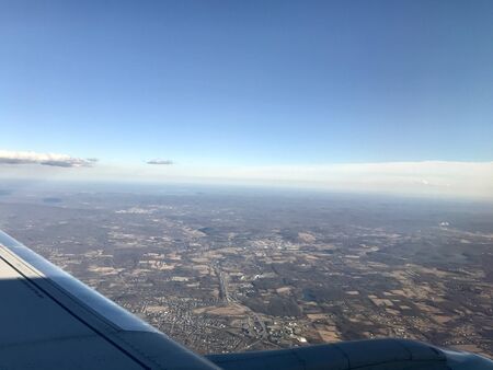 Beautiful birds eye view scene from air travel: Tranquil scenery of the airplane flying high above idyllic landscapes with its long wingの写真素材