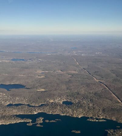 Bird's-eye view of untouched rural countryside: scenic fields, brown hills, trees & lakes create a calm beauty lakes from flying high up in the atmosphereの写真素材