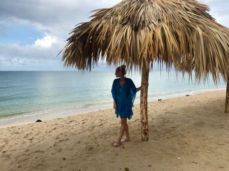 Pretty blonde female model on the sandy beach of Playa Ancon in Cuba in a panorama of a tropical paradise enjoying her relaxing vacationの写真素材