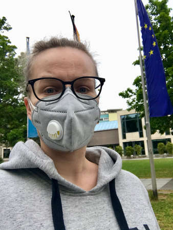 Young blonde caucasian women wearing a professional surgical N95 mask as a protection for the Covid 19 pandemic diseaseの写真素材