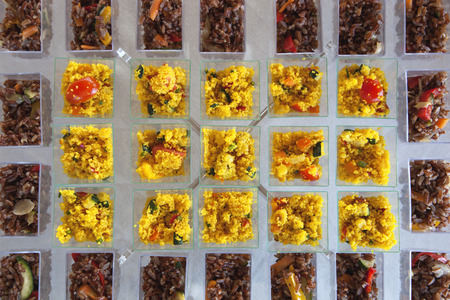 a close up of a wedding buffet table with cous cous verrines and black rice verrineの写真素材