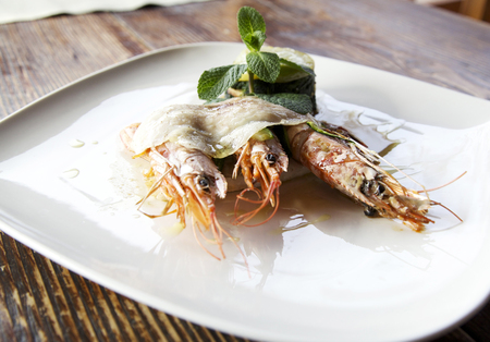 big prawns covered with thin slices of Colonnata lard and a spinach salted pie with crisp potatoesの写真素材
