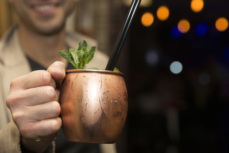 A men is holding a moscow mule, with focus on the drink.の写真素材