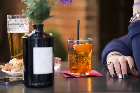 closeup of a woman waiting at the table with a spritz cocktail の写真素材
