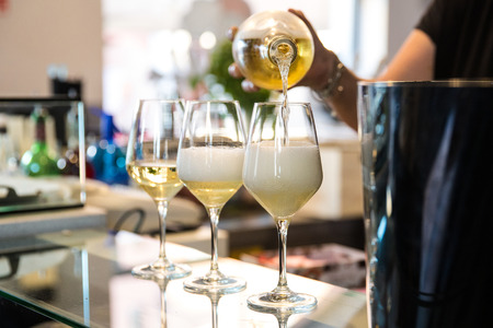 a barmaid is serving 3 glasses of prosecco on the bar cunter