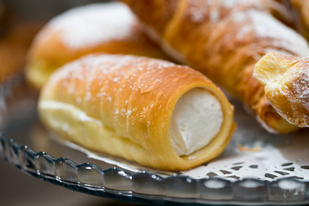 italian cannolo filled with whiped cream on a bar counterの写真素材