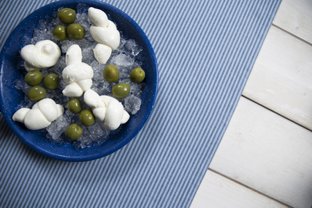 summer appetizer served in a pan with ice, green olives and fresh nodini, little bows of mozzarella. subject on the leftの写真素材