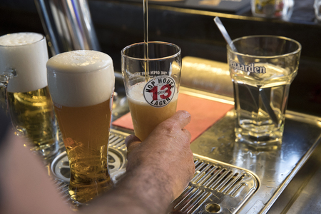 PIACENZA, ITALY - JUNE 15, 2018: closeup of a barman tapping a  Guinness Hop House 13 Lager behind a bar counterのeditorial素材
